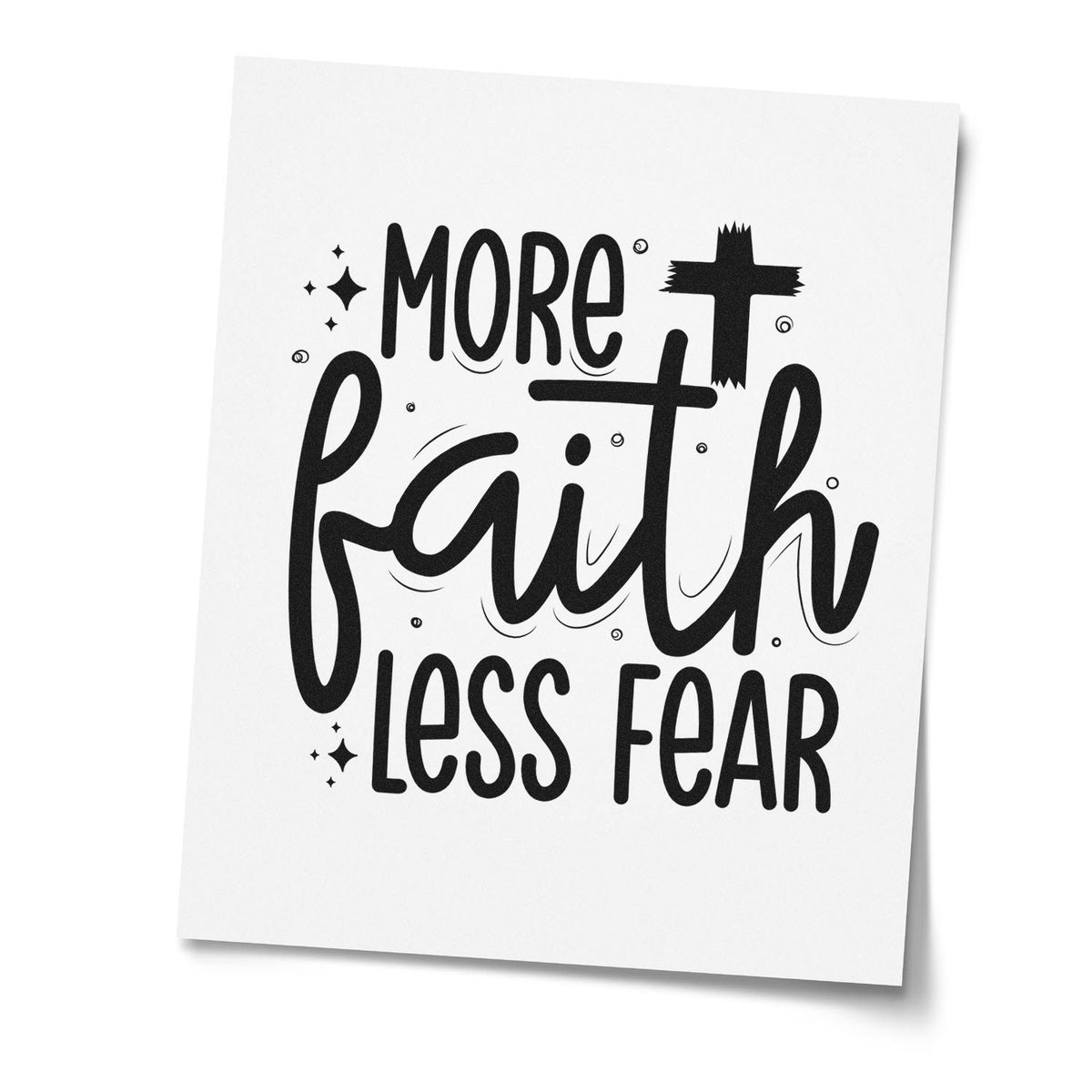 Black rubber stamp design on white paper reading More Faith Less Fear with bold lettering and small sparkle accents.
