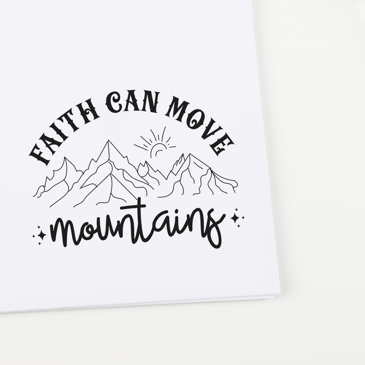 Black custom stamp seal with Faith can move mountains, mountain line art, sun, and sparkles on white paper.