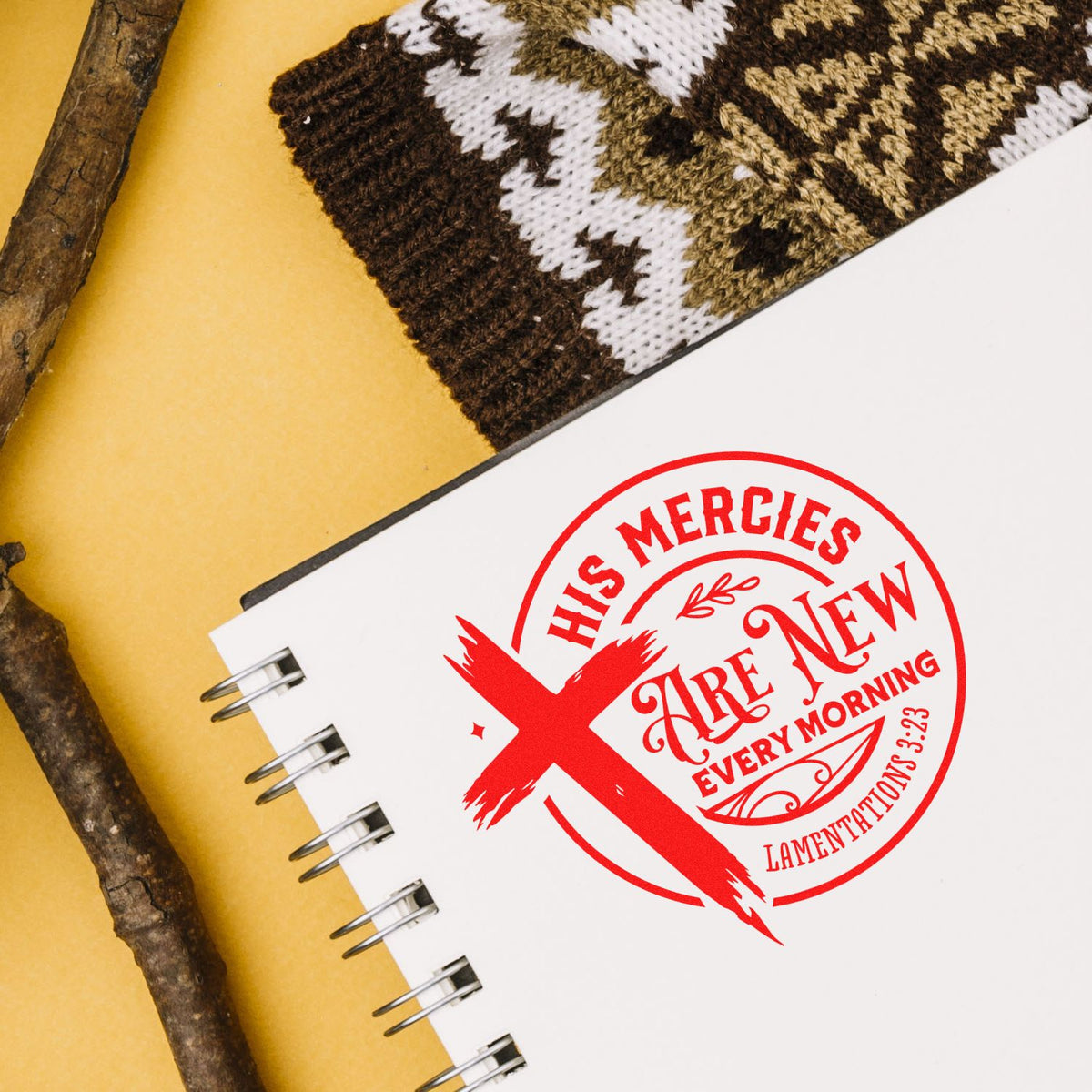 White spiral notebook featuring a red Christian stamp seal with cross and His mercies are new every morning on a yellow background.