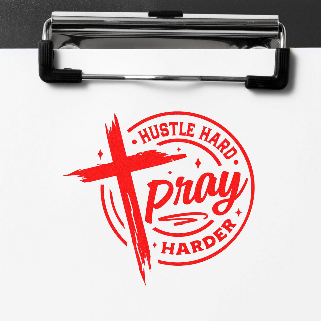 Red custom stamp seal reading Hustle Hard Pray Harder on white paper, clipped to a clipboard.