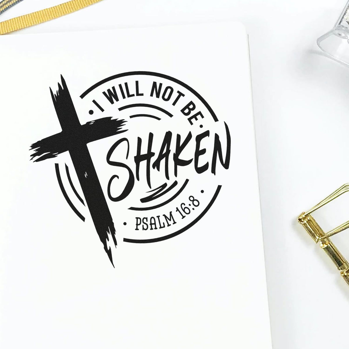Black custom stamp seal with cross and I Will Not Be Shaken, Psalm 16:8 on white paper with gold accents.