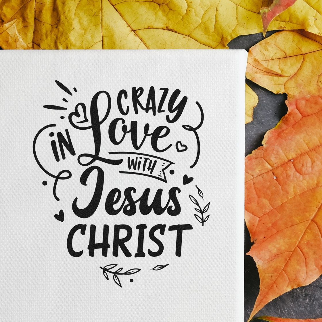 Black decorative stamp design reading Crazy in Love with Jesus Christ on white cardstock, with yellow and orange autumn leaves.