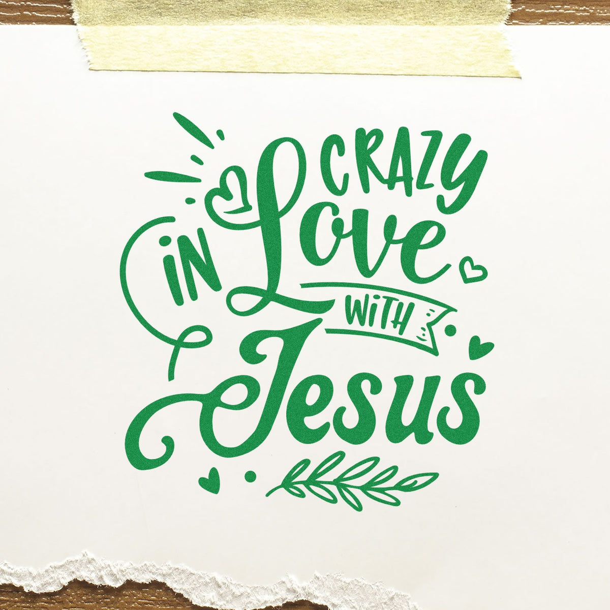 Green craft stamp/seal reading Crazy in Love with Jesus, with hearts and leaf accents on white paper.