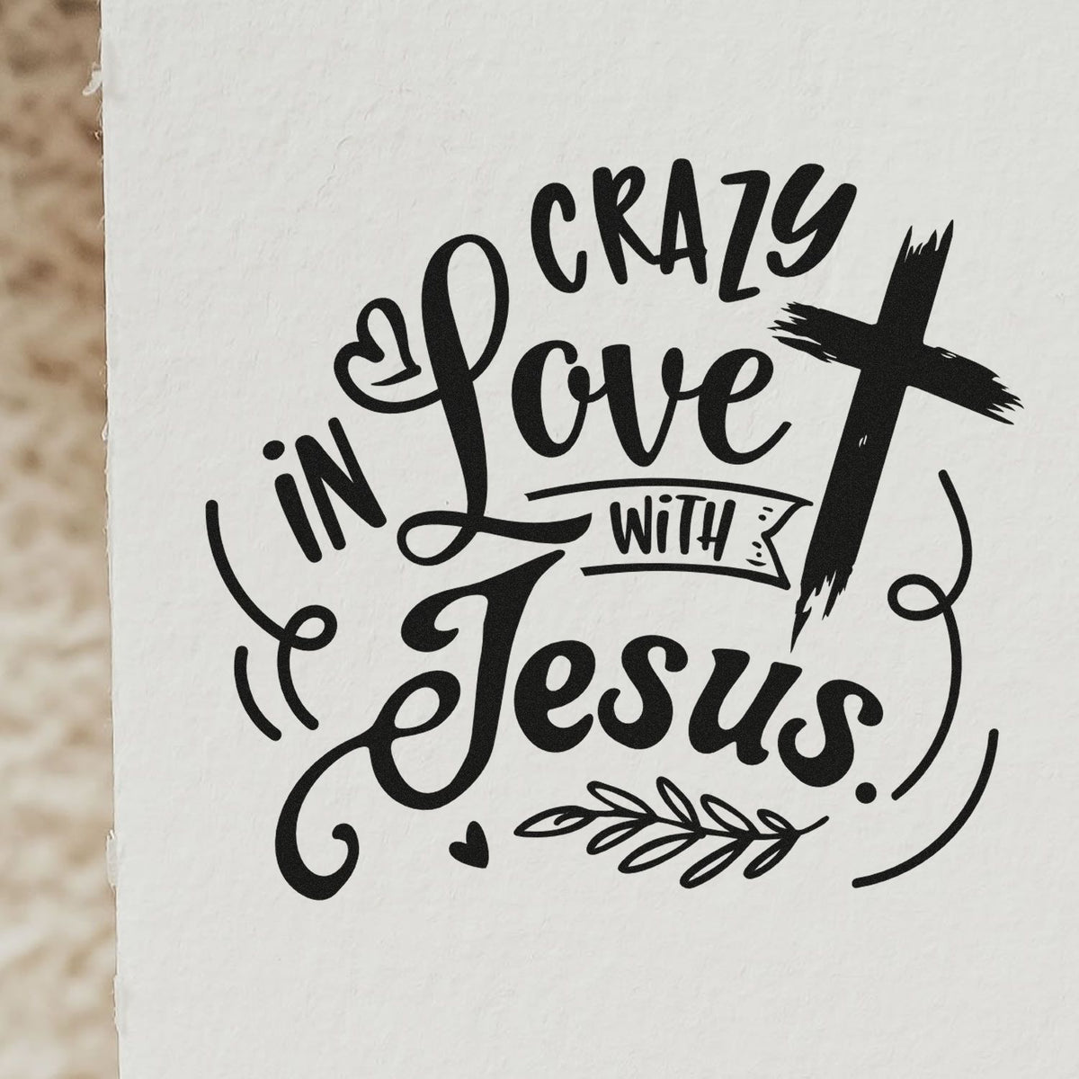 Black rubber stamp/seal design reading Crazy in Love with Jesus with cross, hearts and leaf on white background.