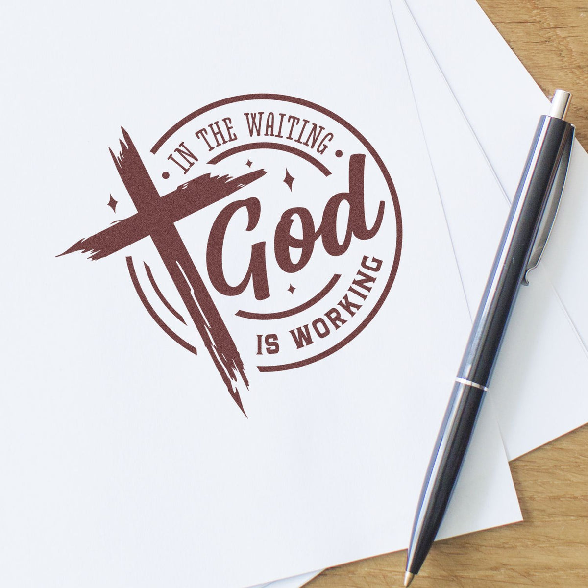 Brown custom stamp seal reading Good is working on white paper, with a black pen on a wooden desk.