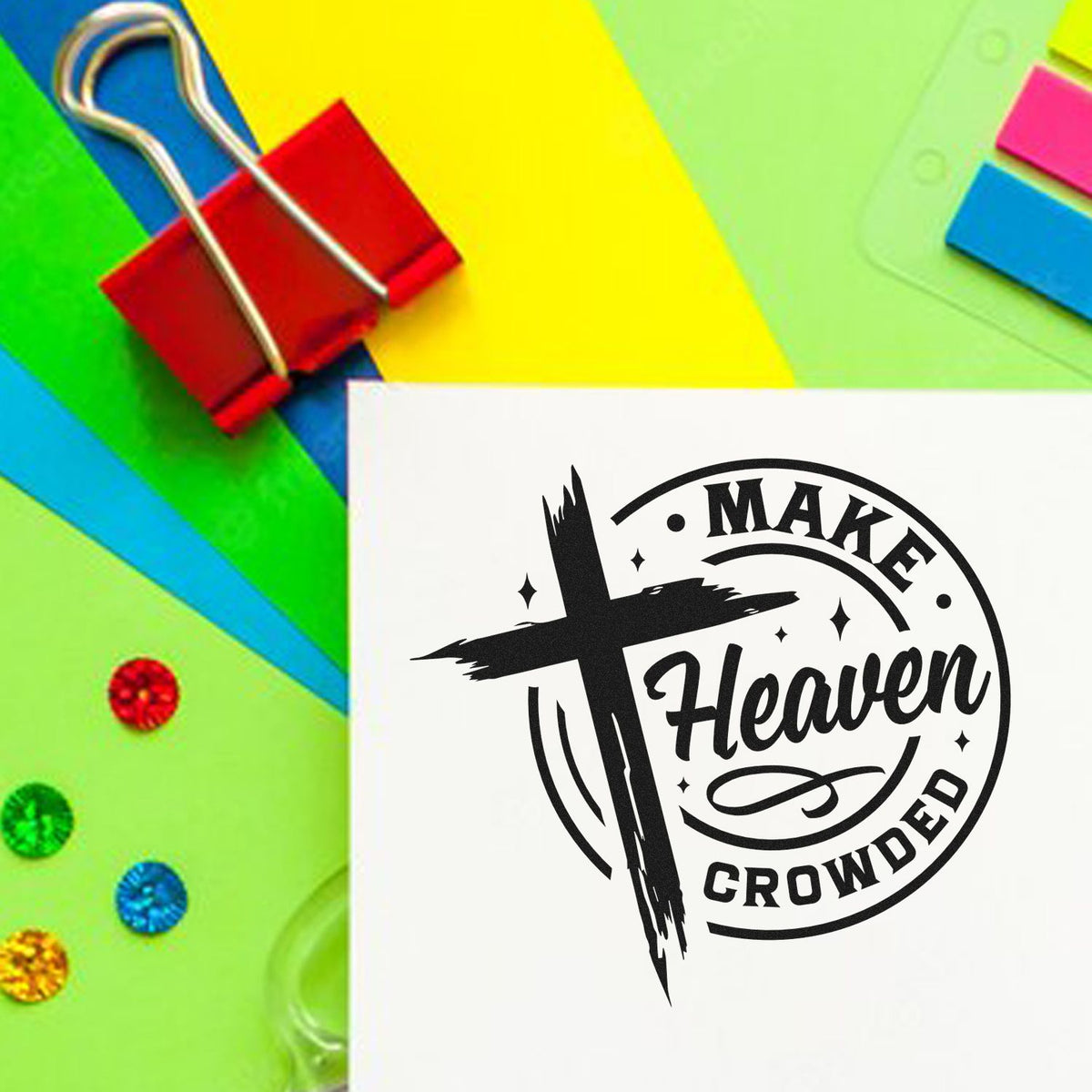 Black Make Heaven Crowded stamp and seal design on white card, with red clip and bright neon paper background.