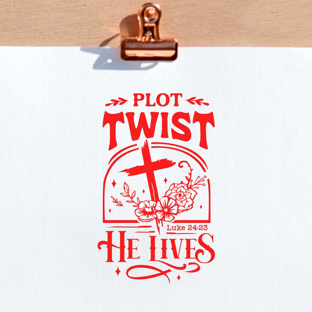 Red custom stamp seal on white paper, reading Plot Twist He Lives with cross, flowers, and Luke 24:23.