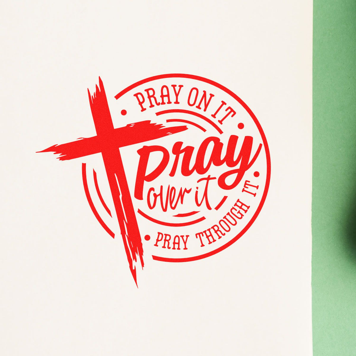 Red circular prayer stamp seal with cross and Pray on it, Pray through it on white background with green edge.