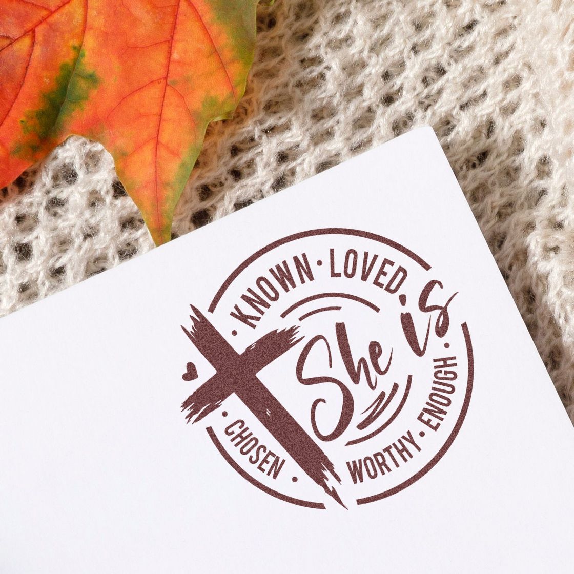 Brown circular faith stamp seal on white paper, featuring a cross and the words Known, Loved, Chosen, Worthy, Enough, She.