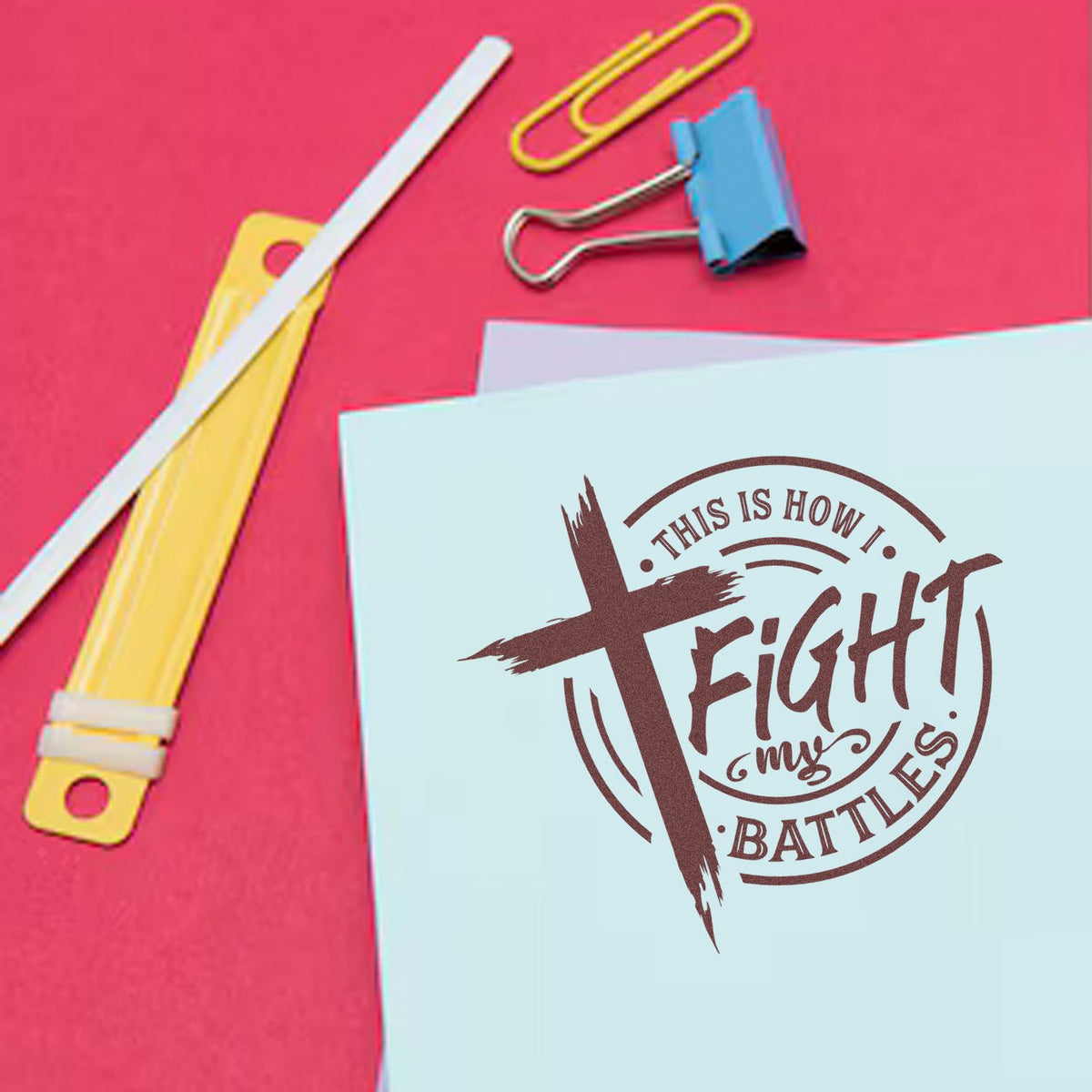 Light blue stationery with a brown custom stamp seal reading This Is How I Fight My Battles, beside yellow and blue clips.