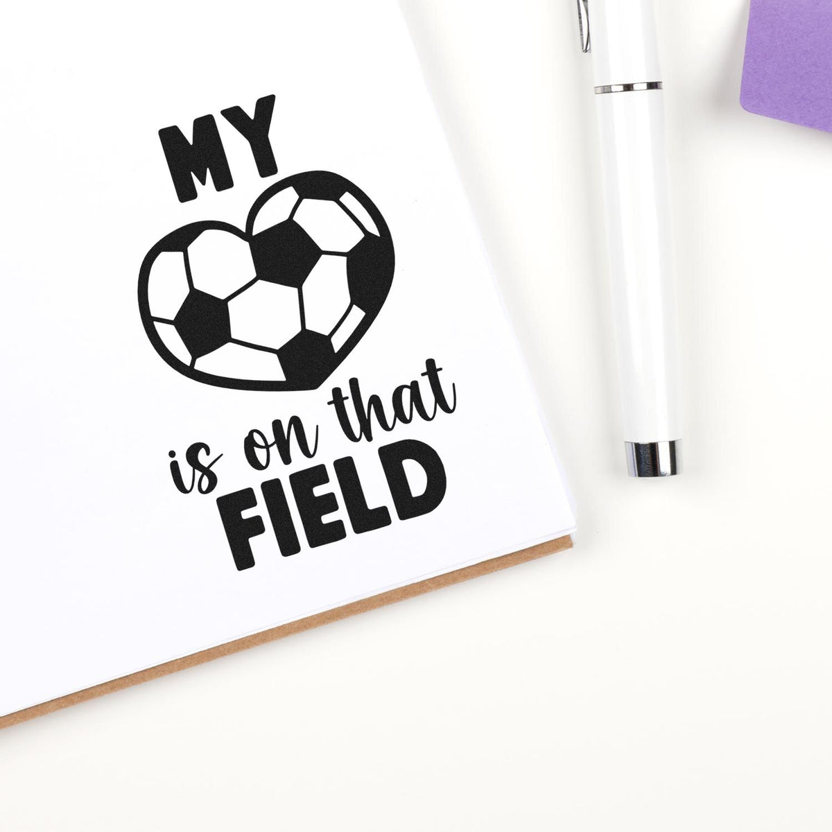 Custom stamp and seal design: black soccer heart and My is on that FIELD on white card, with white pen and purple accent.