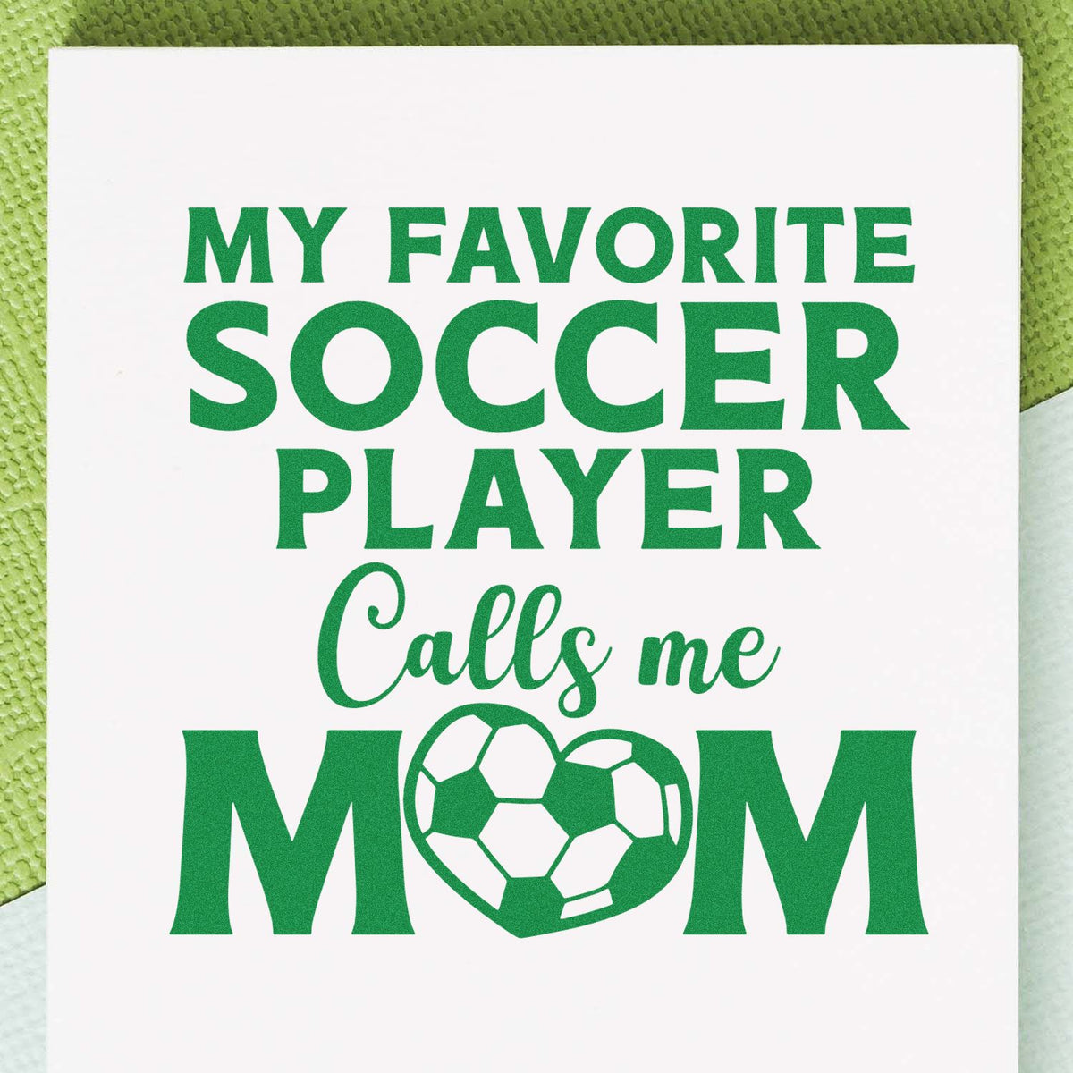 Green custom stamp reading My favorite soccer player calls me mom with a soccer-ball O on a white background.