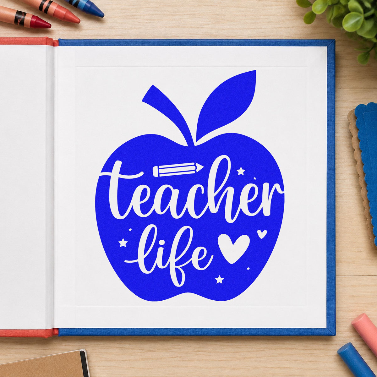 Teacher Life Apple craft stamp imprinted in blue ink on paper, a design suited to supply bin labels.