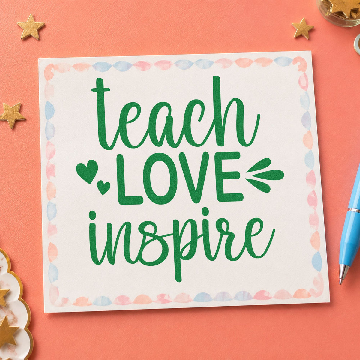 Teach Love Inspire Hearts craft stamp imprint in green ink on a handmade project, one idea being art show pages.