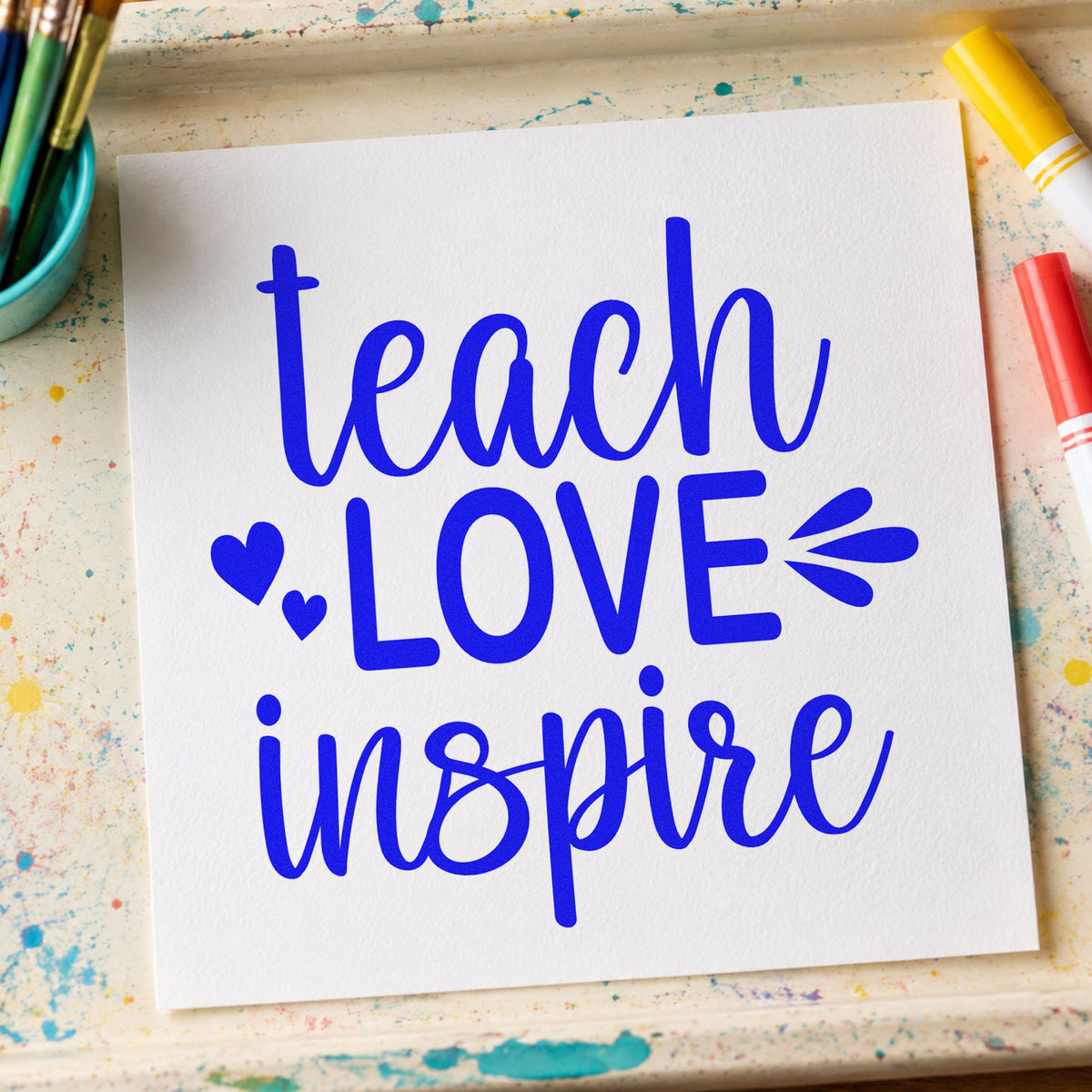 Teach Love Inspire Hearts craft stamp in blue ink on cardstock, an easy option for canvas corner panels.