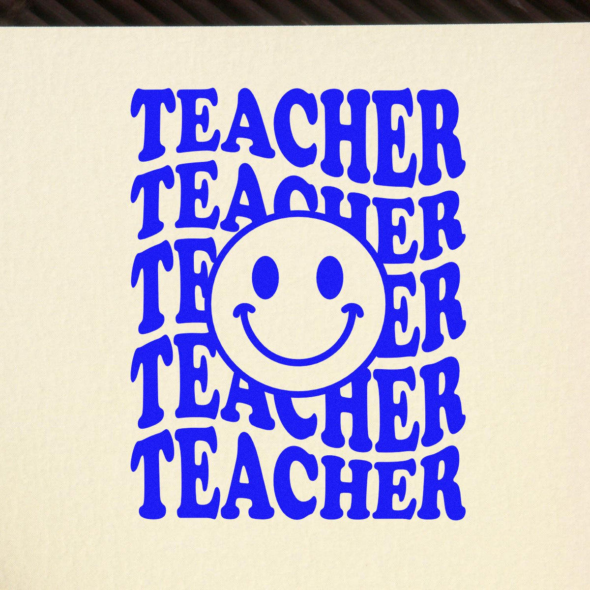 Blue teacher stamp with a smiling face seal on cream paper, bold retro lettering in vivid blue.