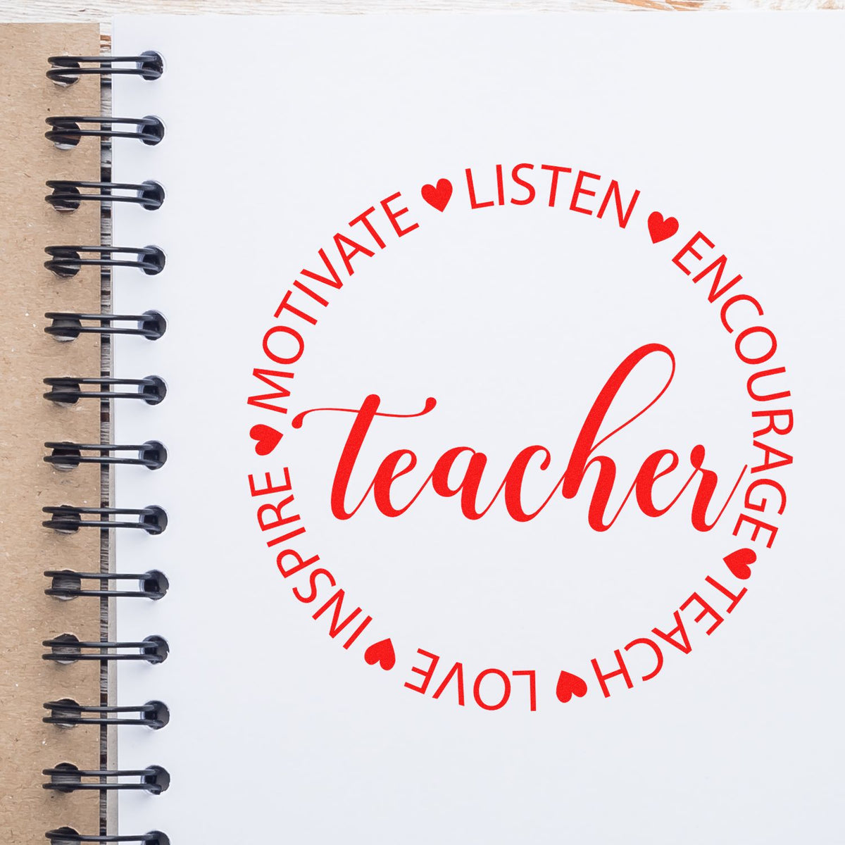 Red round teacher stamp seal with hearts on white spiral notebook page