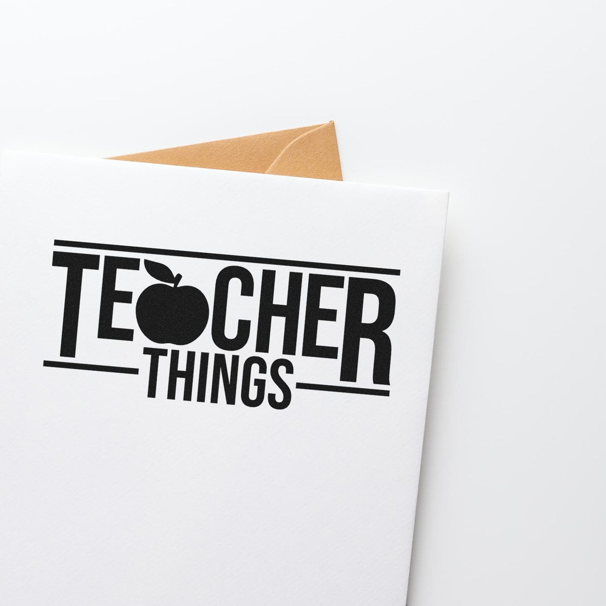 Black Teacher Things stamp on a white envelope, with a tan seal and bold black lettering with an apple icon.