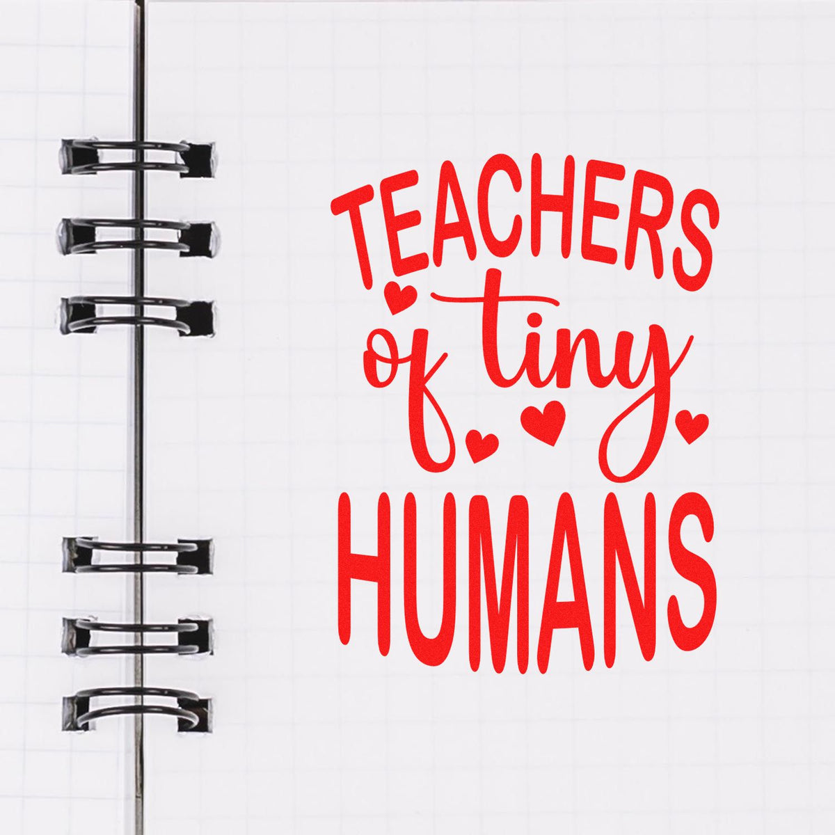 Red Teachers of Tiny Humans stamp and seal design with hearts on white notebook page and black spiral binding.