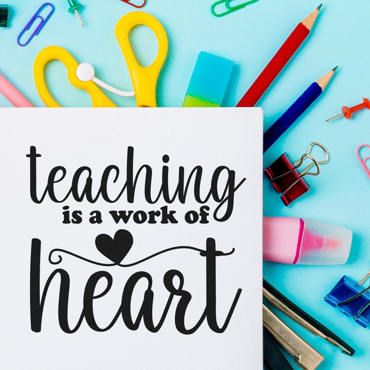 Teaching is a work of heart stamp and seal design on white paper, with colorful scissors, pencils, and binder clips on aqua.