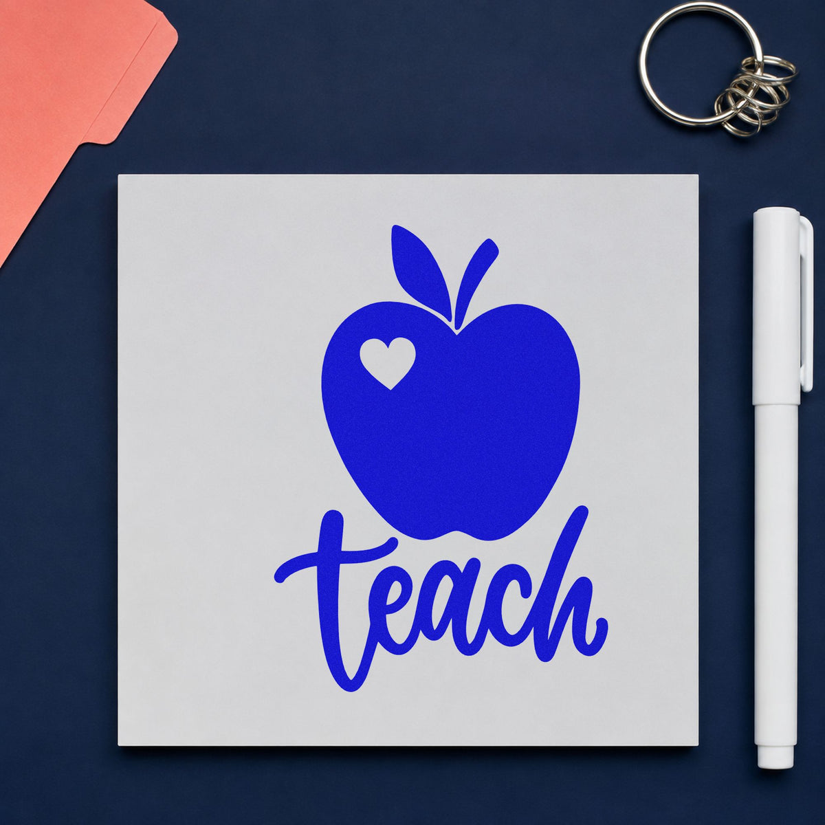 Teach Apple Heart craft stamp imprinted in blue ink on paper, a design suited to kraft seal labels.