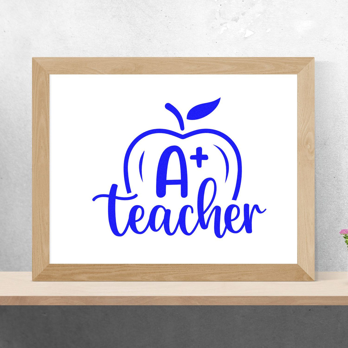 A Plus Teacher Apple rubber stamp shown in blue ink, stamped for projects such as report card tags.