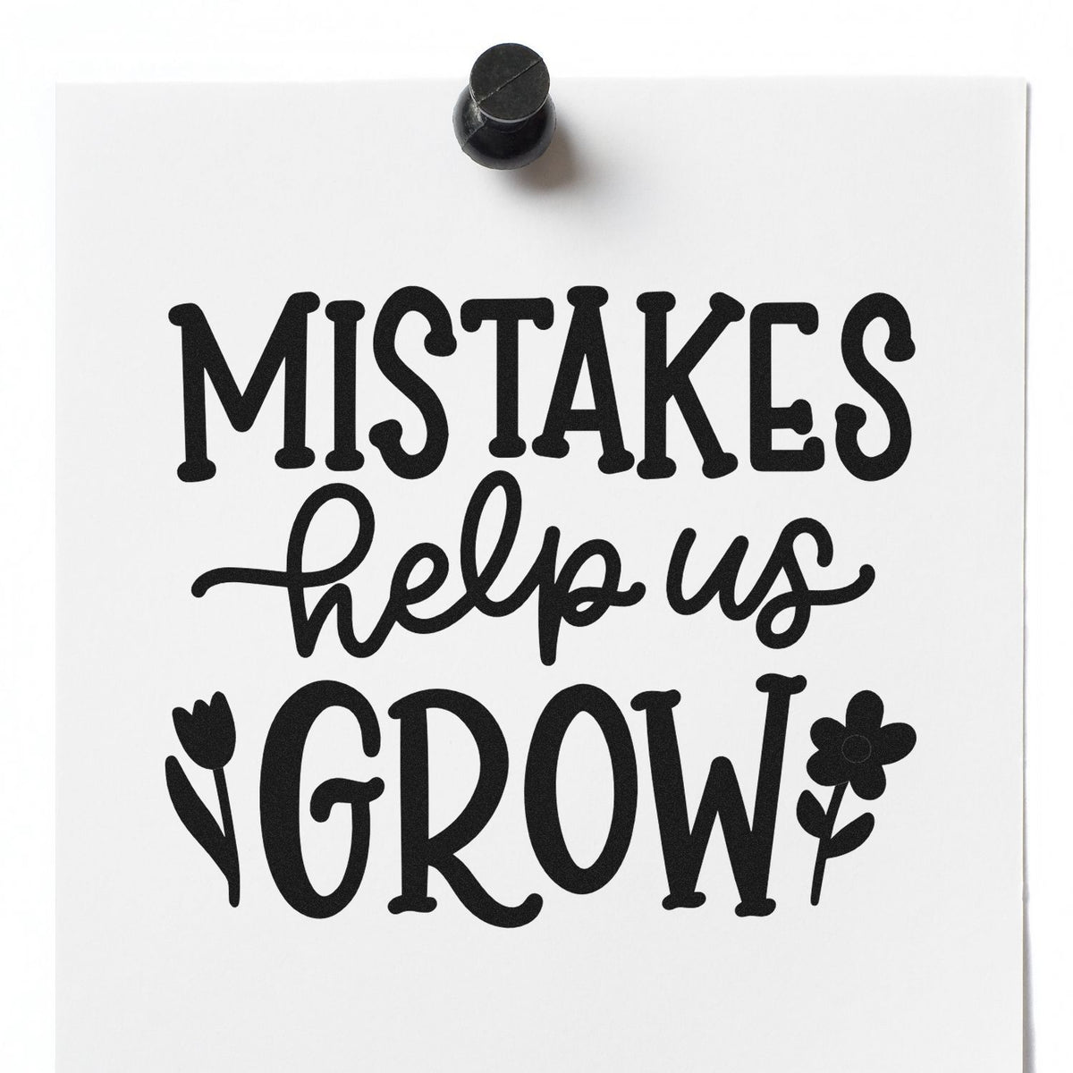 Black stamp seal on white paper reading MISTAKES help us GROW with flower accents.