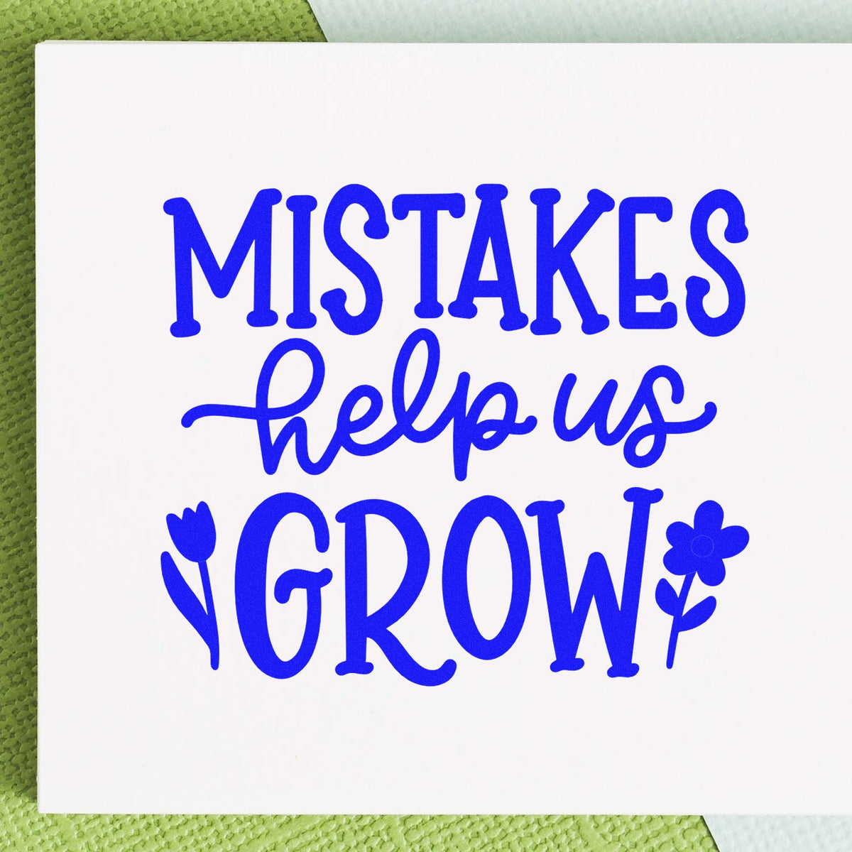 Blue decorative stamp seal reading Mistakes help us grow with tulip and flower accents on a white card.