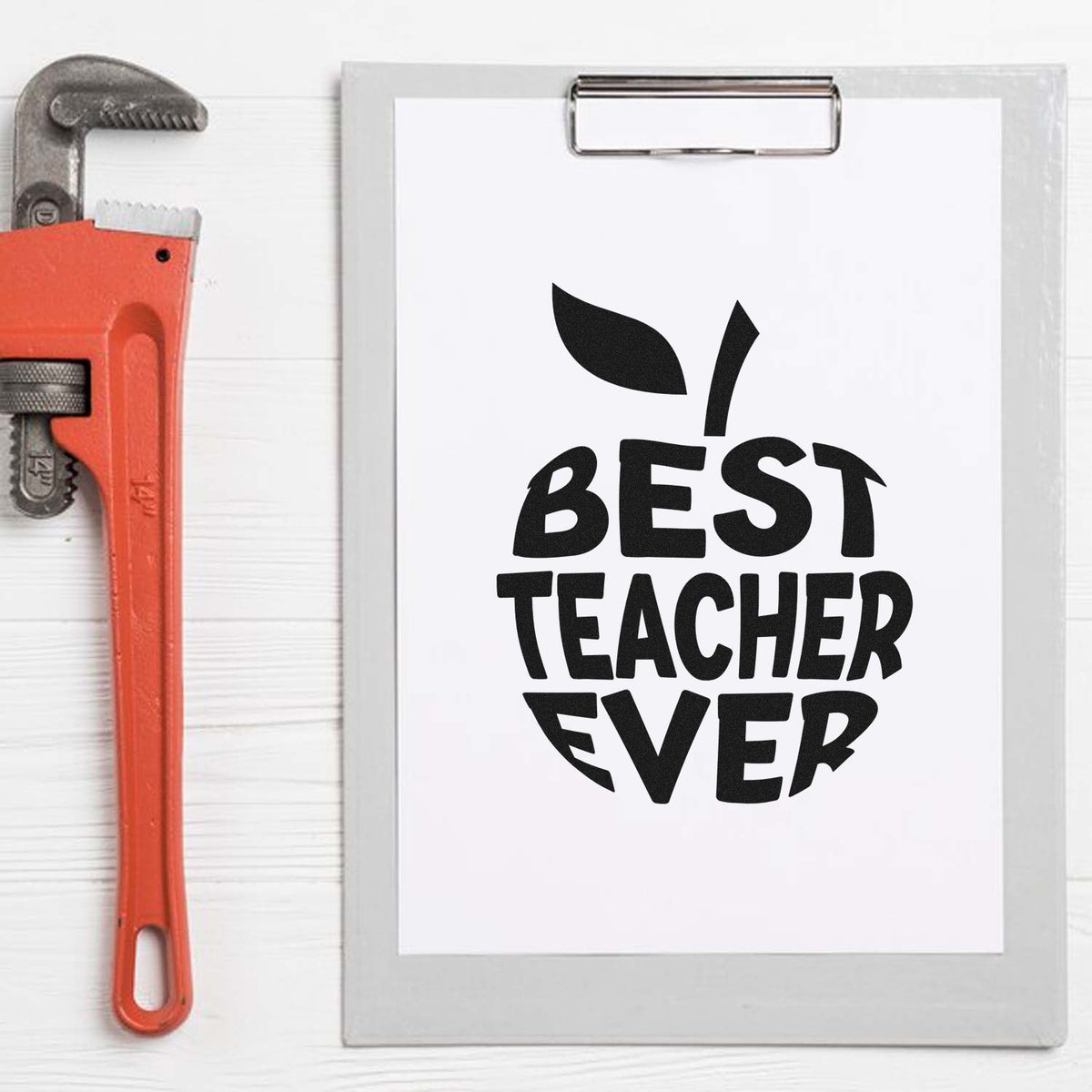 Black Best Teacher Ever stamp and seal design on clipboard, with gray clip and orange wrench.