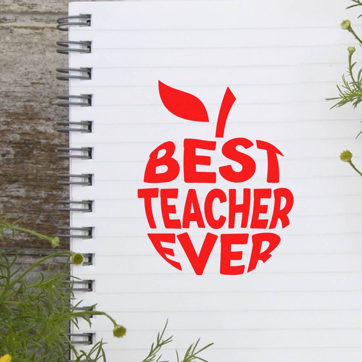 Red Best Teacher Ever stamp seal on a white spiral notebook cover with bold red lettering.