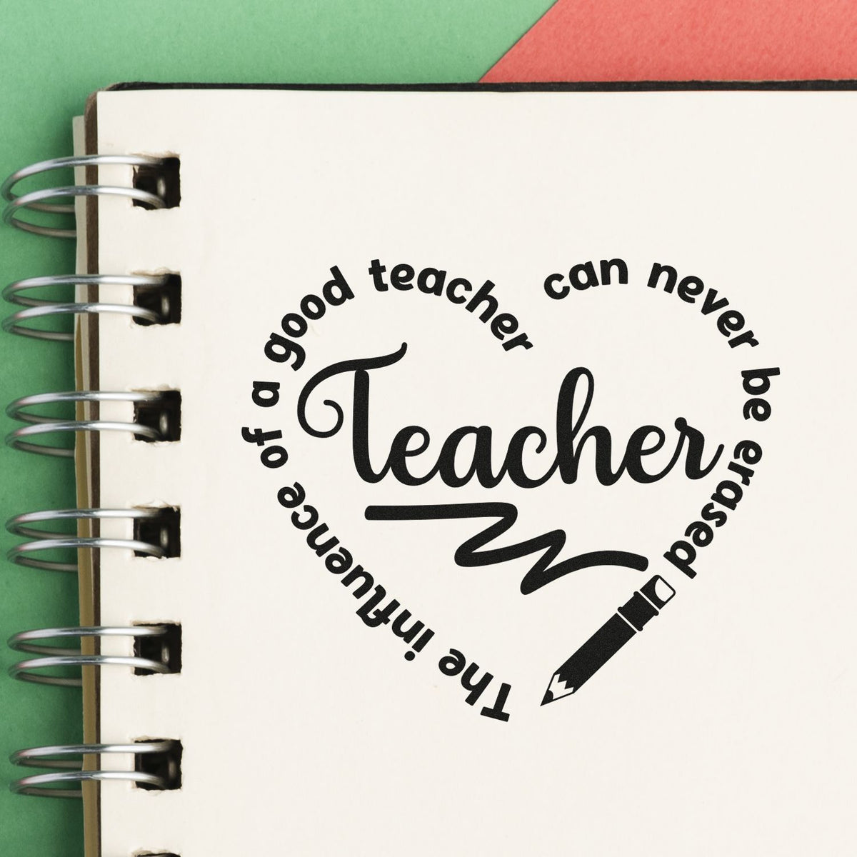 Black teacher stamp seal on a white spiral notebook, with pencil icon and green-red background.