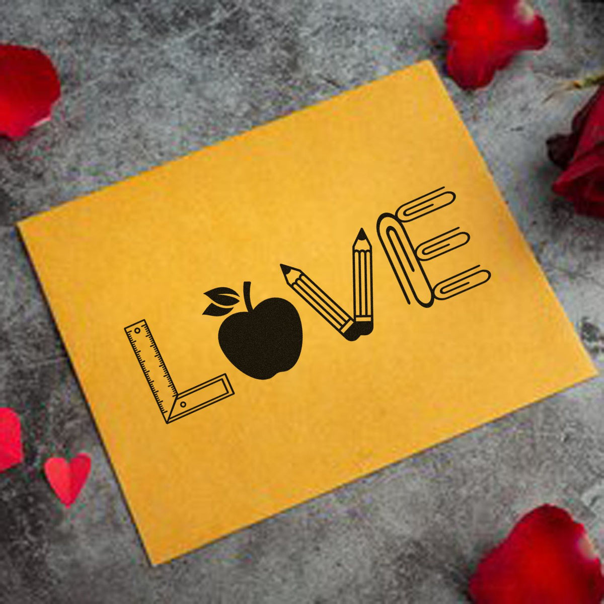 Yellow stamp and seal products card with black pencil, apple, and ruler logo on gray stone with red rose petals.