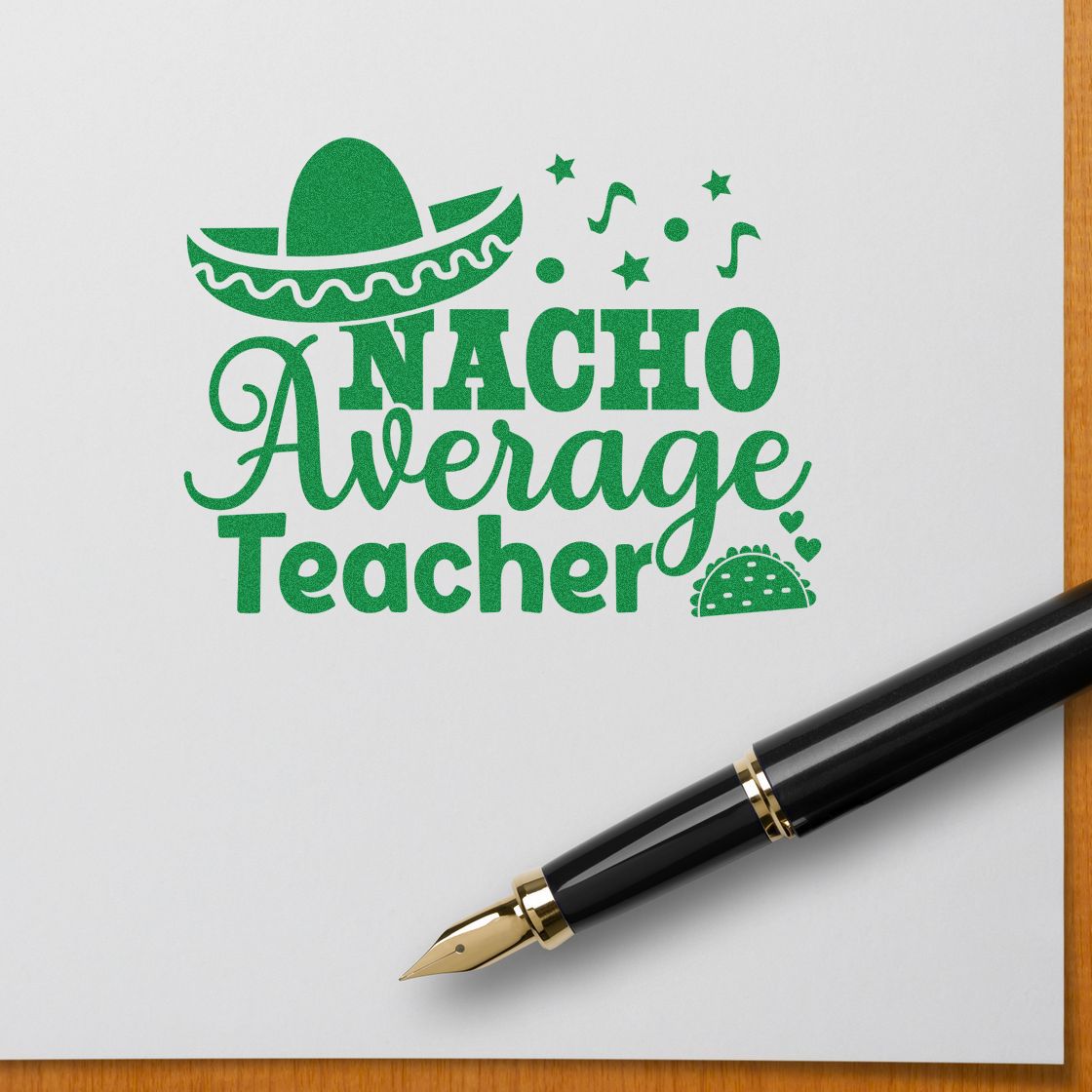 Green Nacho Average Teacher stamp with sombrero, stars, and hearts on white paper beside a black fountain pen.