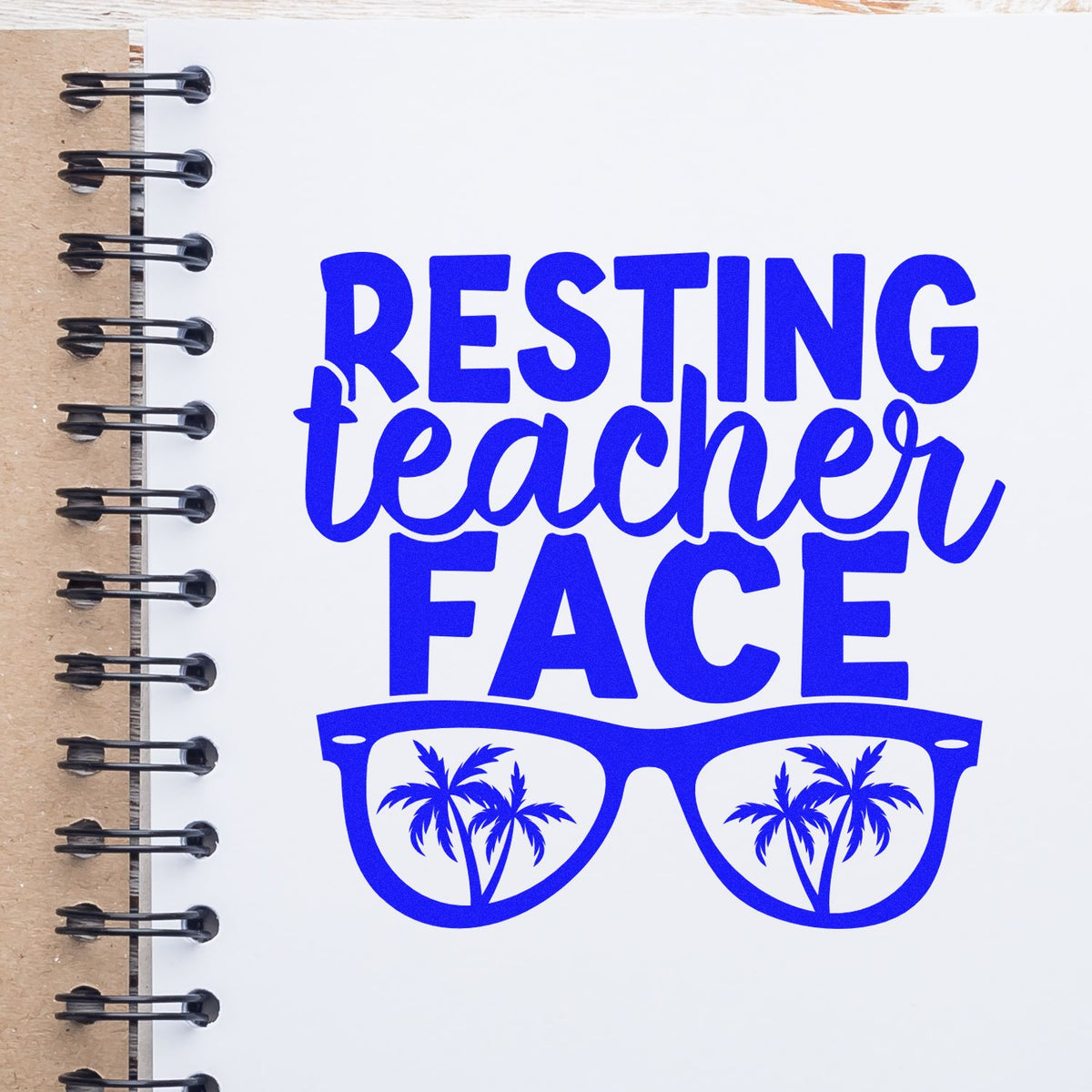 Blue Resting Teacher Face stamp design with sunglasses and palm trees on a spiral notebook page.