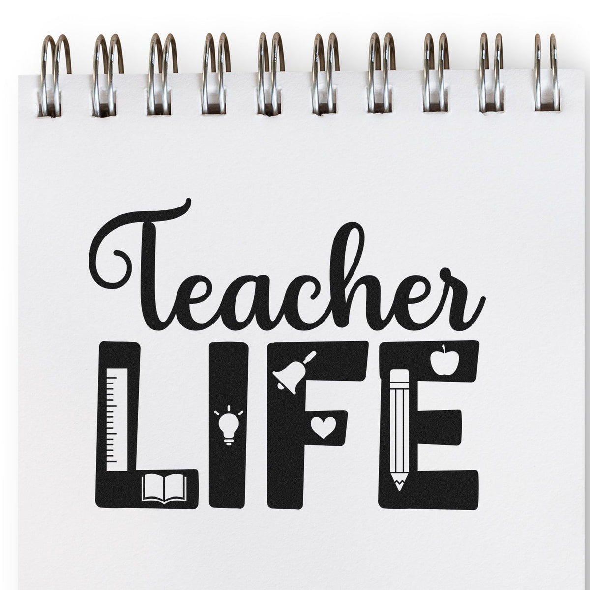 Black Teacher LIFE stamp seal on white spiral notebook page, with ruler, book, lightbulb, bell, apple and pencil icons.