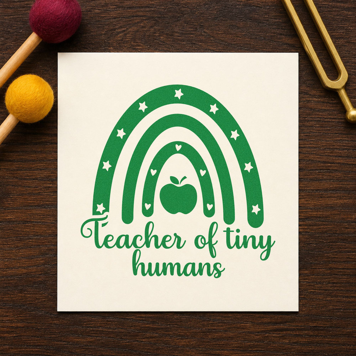 Teacher of Tiny Humans Rainbow craft stamp imprint in green ink on a handmade project, one idea being framed toddler wall.