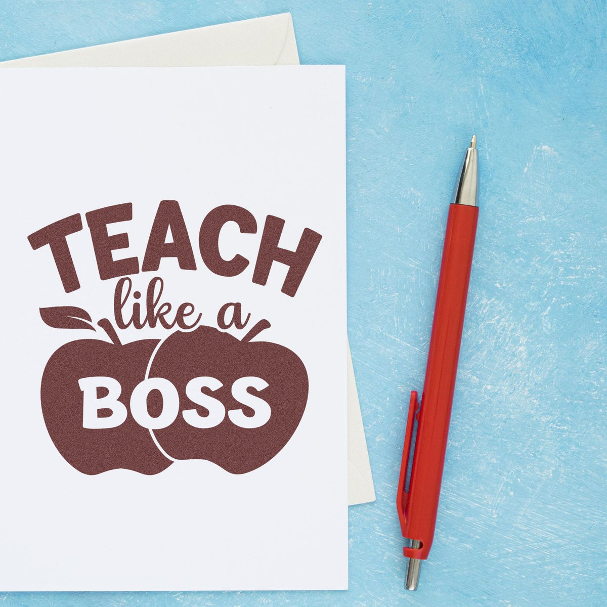 Brown Teach like a Boss teacher stamp and seal on white paper with a red pen on a textured blue background.