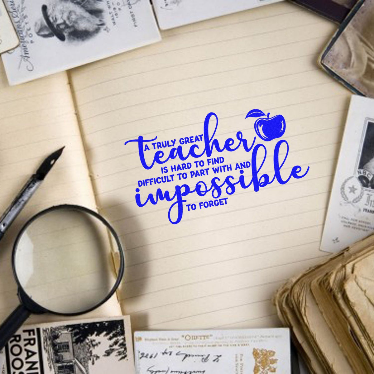 Blue teacher quote stamp with apple icon on lined paper, surrounded by stamp and seal samples and stationery.