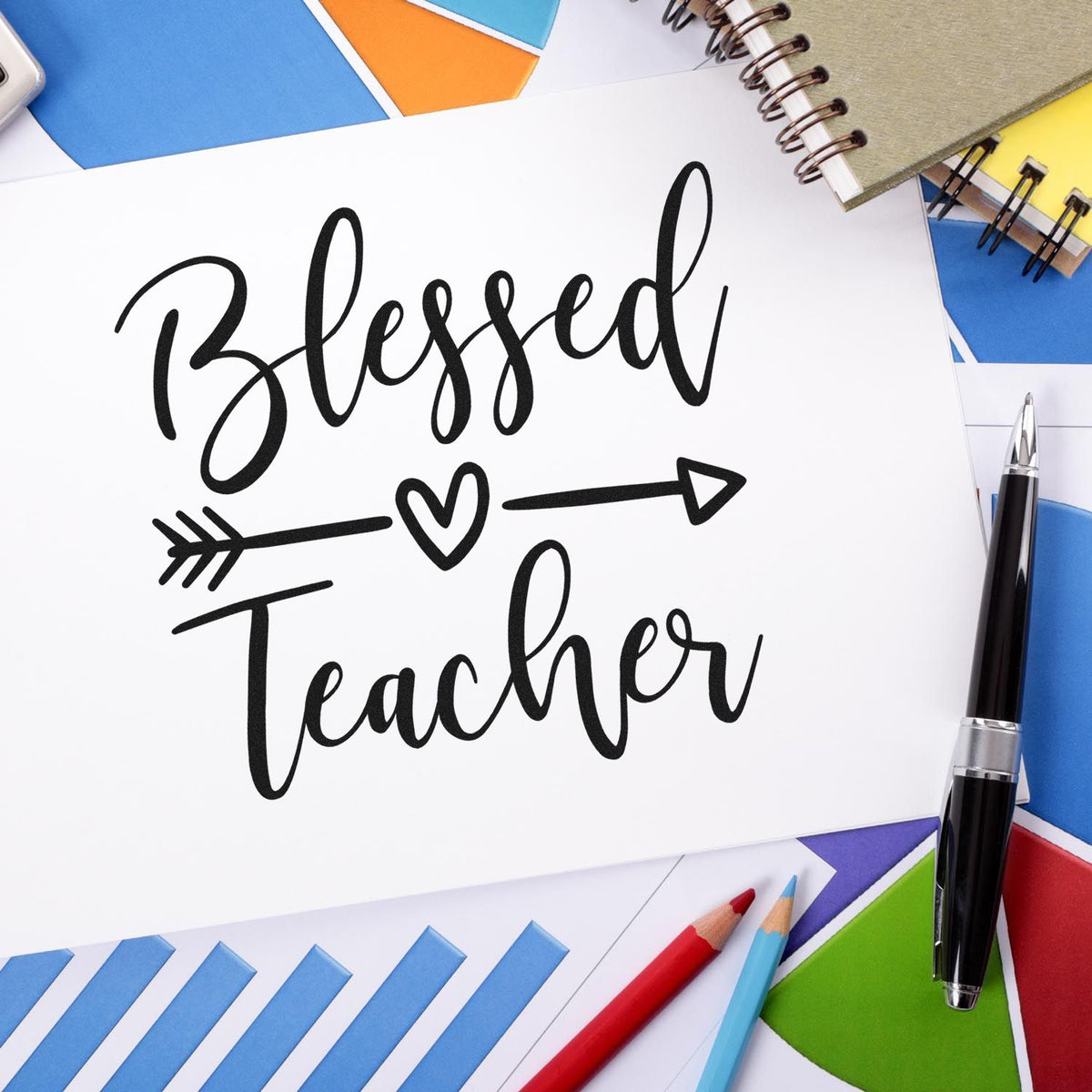 Black Blessed Teacher stamp/seal design with heart arrow, on white card, surrounded by blue, yellow, green and red stationery.
