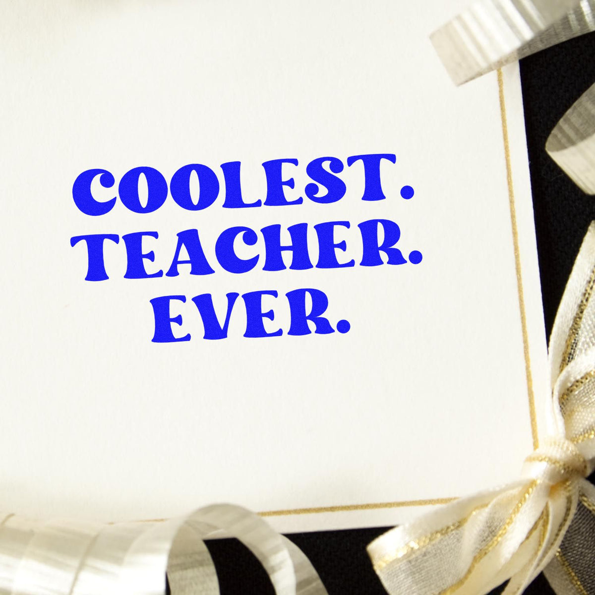 Blue COOLEST TEACHER EVER stamp seal on white card, finished with cream and gold ribbon bows