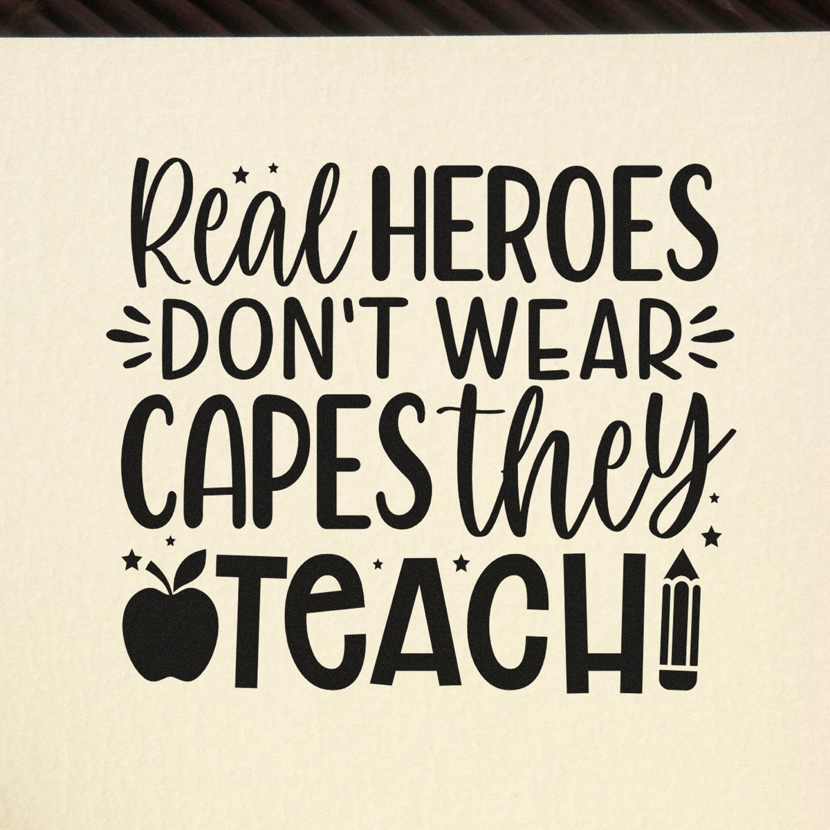 Black teacher appreciation stamp on cream background with apple, pencil and stars; quote: Real heroes dont wear capes, they teach.