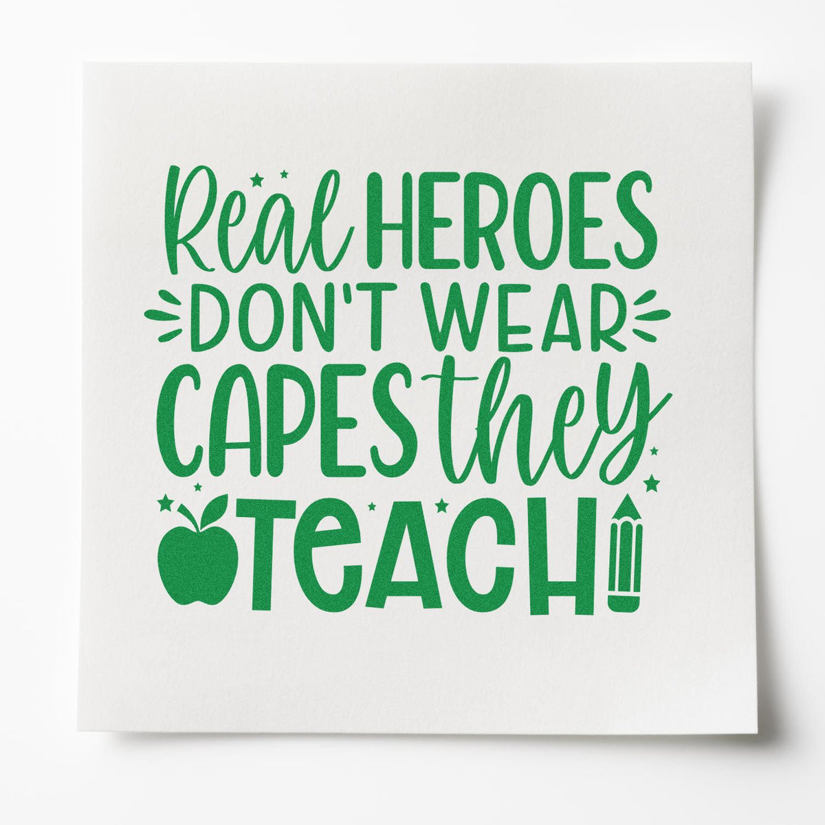Green teacher stamp design on white paper, with apple and pencil icons and text: Real heroes dont wear capes, they teach!