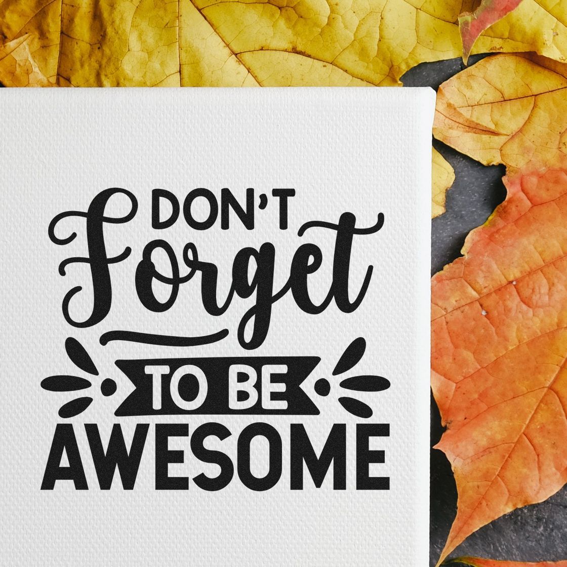 Black motivational stamp seal reading Dont Forget to Be Awesome on white textured paper, framed by yellow and orange autumn leaves.
