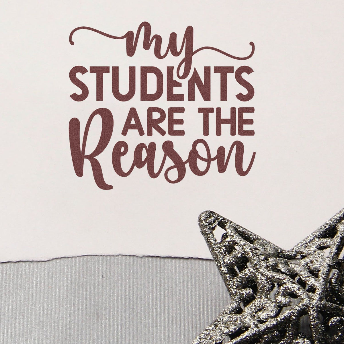 Burgundy my students are the reason stamp with silver glitter star seal on white paper.