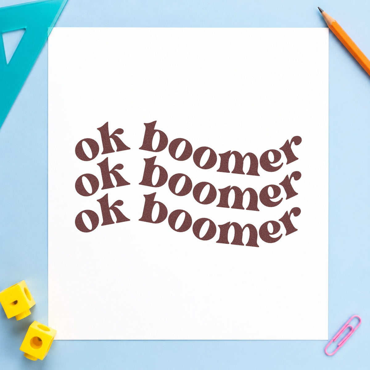 Repeated Wavy Ok Boomer rubber stamp printed in brown ink, ready for retro tin labels and similar paper crafts.