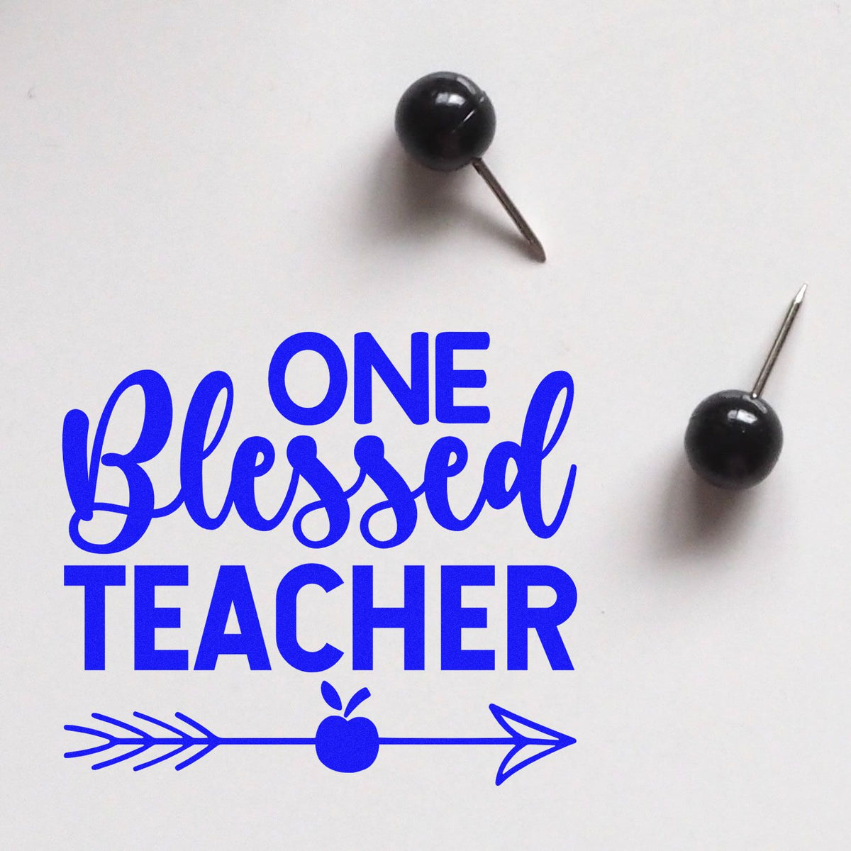 Blue One Blessed Teacher stamp design with arrow and apple, shown with two black pushpin seal products on a white background.