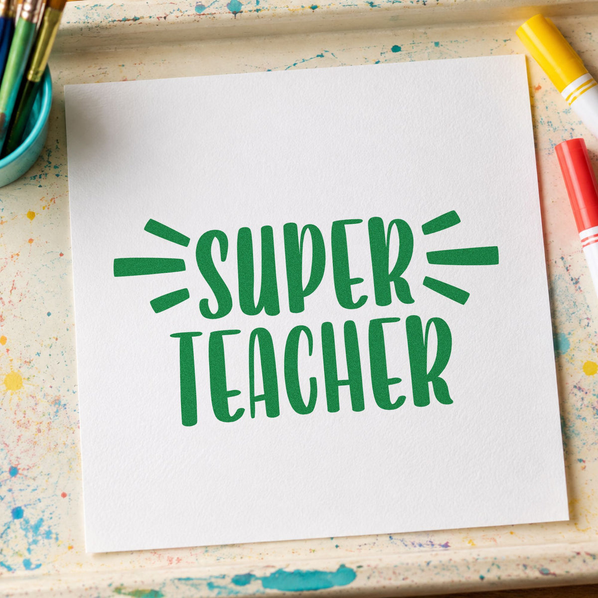 Super Teacher Bold Lettering craft stamp imprint in green ink on a handmade project, one idea being merit chart pages.
