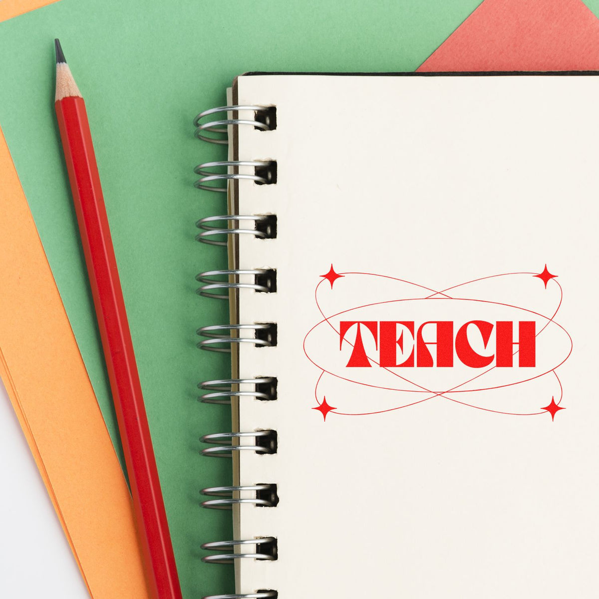 Red TEACH stamp seal on a white spiral notebook beside a red pencil, with green, orange, and coral paper background.