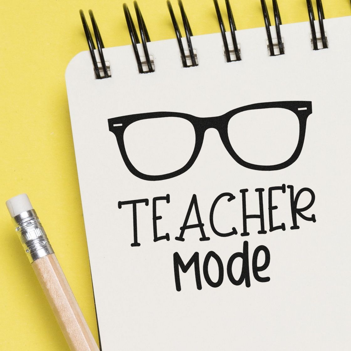 Teacher Mode Eyeglasses Wood Handle Stamp imprint stamped in black ink. A large pair of eyeglasses sits above “Teacher Mode.”