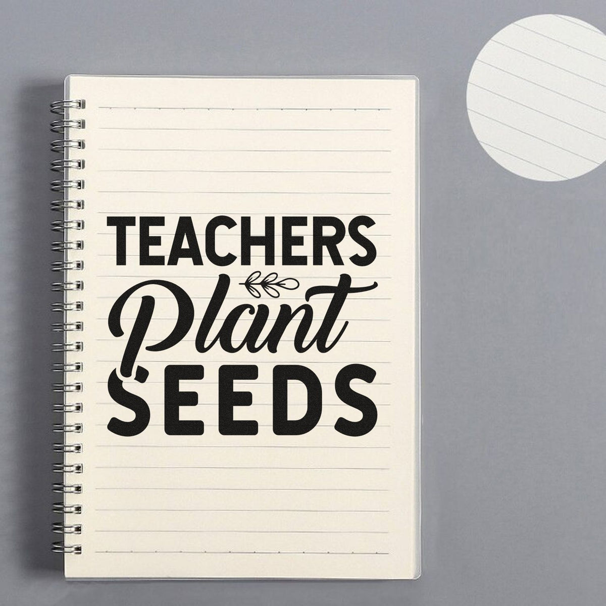 Black Teachers Plant Seeds stamp and seal design on cream spiral notebook with lined paper and gray background.